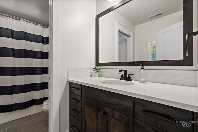 2245 N Burnam Ave, Star, ID 83669 - full bathroom featuring tile patterned flooring, vanity, toilet, decorative backsplash, and visible vents