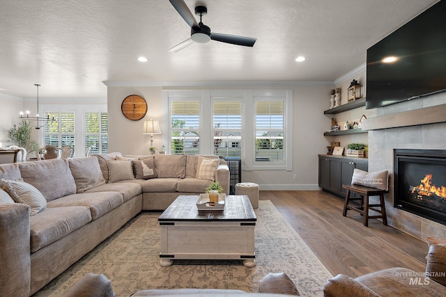 2245 N Burnam Ave, Star, ID 83669 - living area with crown molding, baseboards, ceiling fan with notable chandelier, and wood finished floors