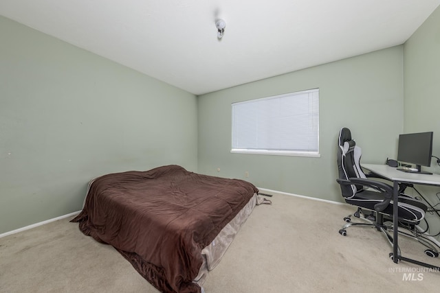 bedroom with light carpet and baseboards