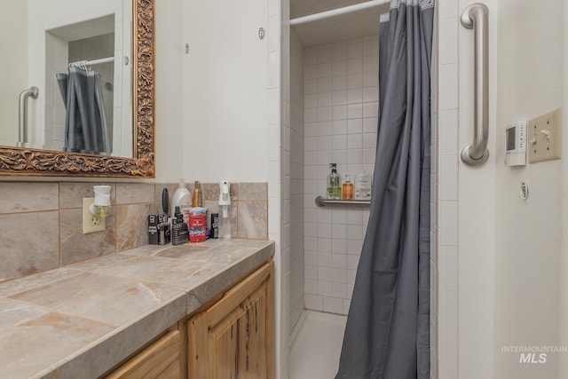 bathroom with a shower stall, vanity, and decorative backsplash