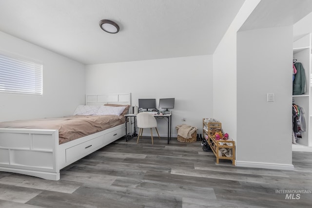 bedroom with dark wood-style flooring and baseboards