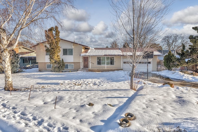 tri-level home featuring an attached garage and brick siding