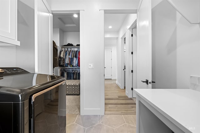 washroom with washer / dryer, cabinet space, light tile patterned floors, and recessed lighting