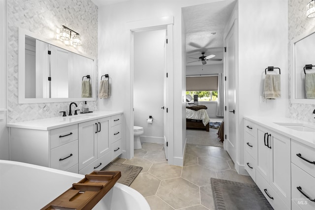 bathroom with ceiling fan, toilet, tasteful backsplash, and a freestanding tub