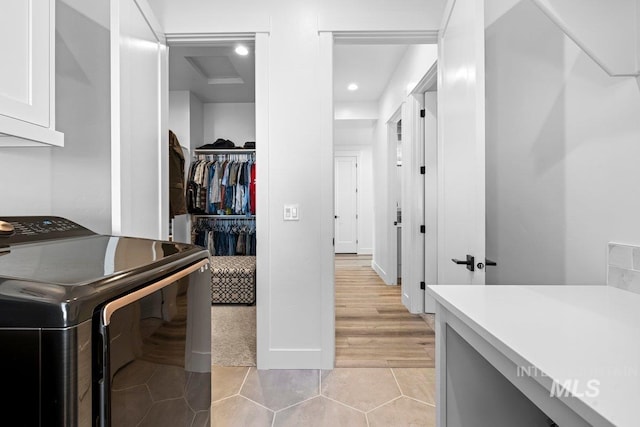 laundry area featuring washer / clothes dryer, cabinet space, light tile patterned floors, and recessed lighting