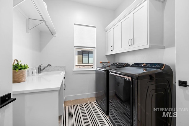 clothes washing area with cabinet space, independent washer and dryer, tile patterned floors, and baseboards