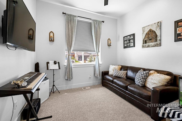 living area featuring carpet and baseboards