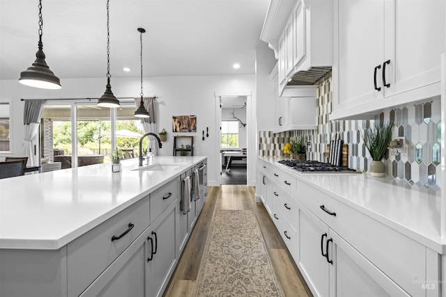 kitchen with a sink, stainless steel gas cooktop, light countertops, light wood-style floors, and recessed lighting