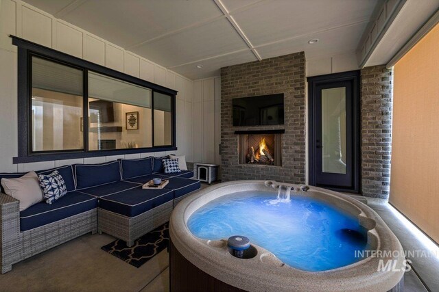 view of patio / terrace with an outdoor living space with a fireplace and a jacuzzi