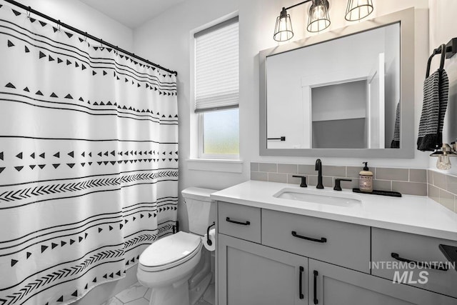 full bath with toilet, tasteful backsplash, and vanity