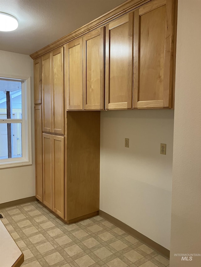 kitchen with baseboards and light floors