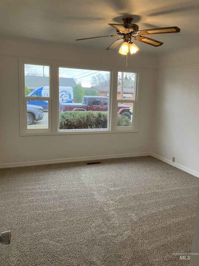 spare room with visible vents, baseboards, carpet, and ceiling fan