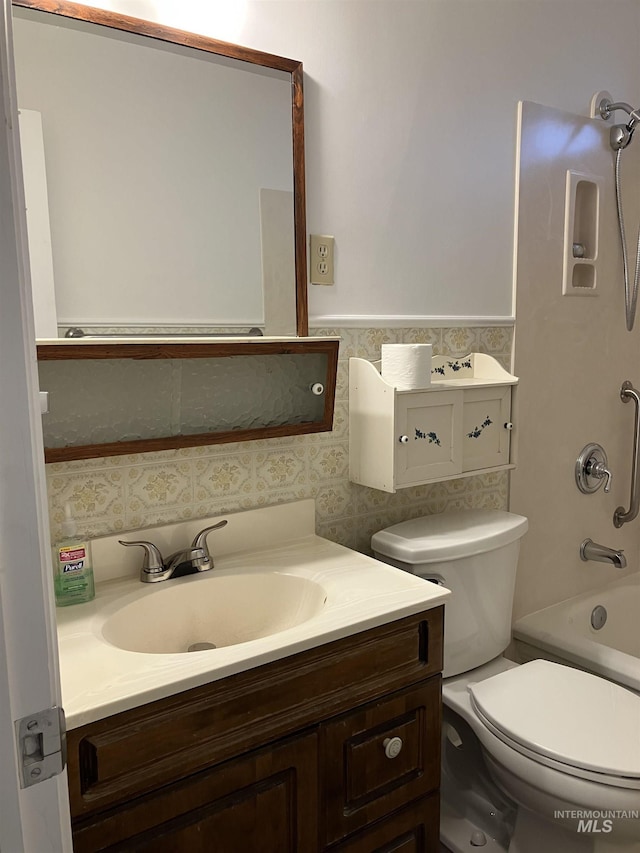 bathroom with toilet, vanity, and shower / bathing tub combination