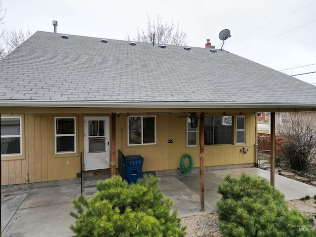 back of house featuring a shingled roof, a patio, and fence