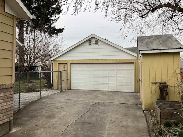 garage with driveway and fence