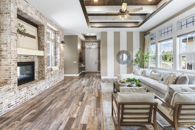 1747 N Tuscolano Ave, Eagle, ID 83616 - living room featuring wood finished floors, a fireplace, a ceiling fan, and a tray ceiling