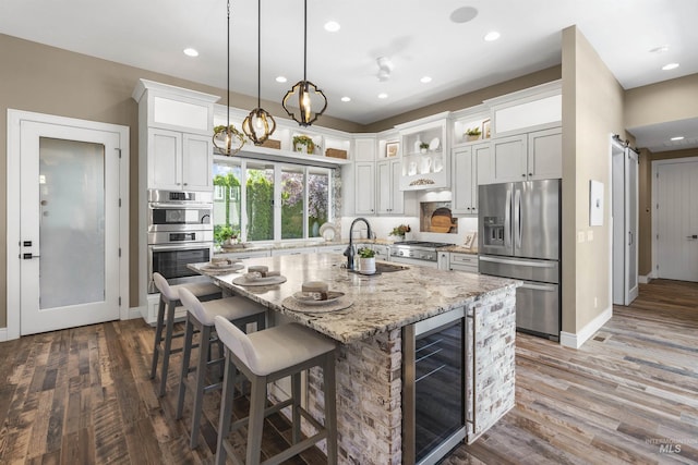 1747 N Tuscolano Ave, Eagle, ID 83616 - kitchen featuring stainless steel appliances, wine cooler, dark wood-style floors, an island with sink, and recessed lighting