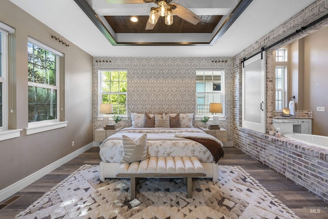 1747 N Tuscolano Ave, Eagle, ID 83616 - bedroom featuring an accent wall, a barn door, wood finished floors, a raised ceiling, and ceiling fan