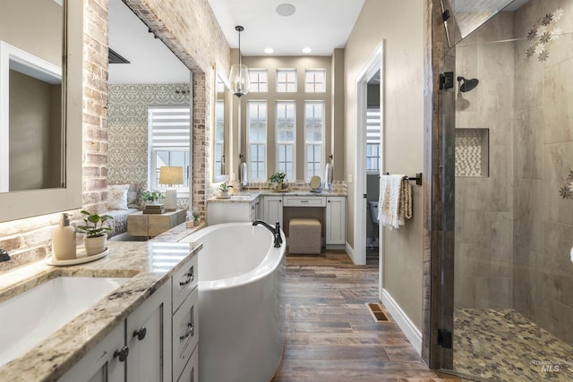 1747 N Tuscolano Ave, Eagle, ID 83616 - full bathroom with a bath, a stall shower, two vanities, and wood finished floors