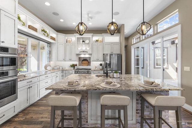 1747 N Tuscolano Ave, Eagle, ID 83616 - kitchen featuring appliances with stainless steel finishes, recessed lighting, dark wood-type flooring, white cabinets, and a kitchen breakfast bar