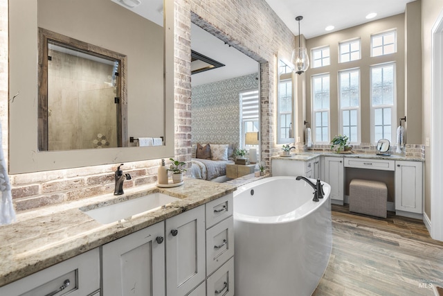 1747 N Tuscolano Ave, Eagle, ID 83616 - bathroom with two vanities, a garden tub, wood finished floors, decorative backsplash, and recessed lighting