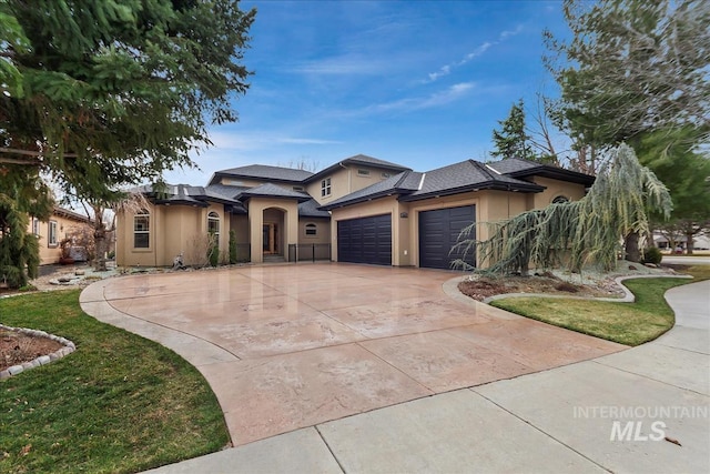 prairie-style home with concrete driveway, an attached garage, and stucco siding