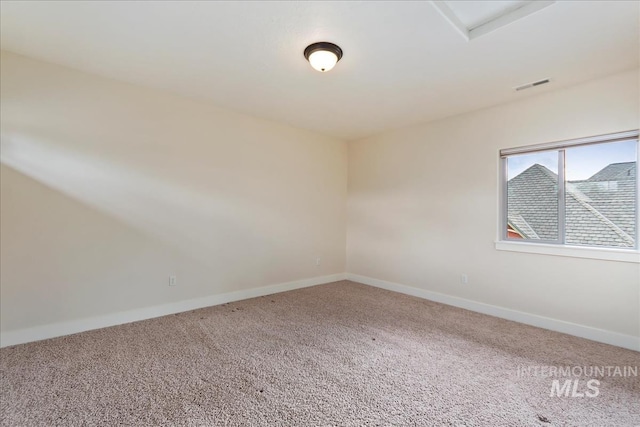 carpeted empty room featuring visible vents and baseboards