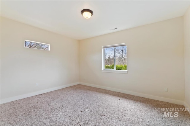carpeted spare room featuring visible vents and baseboards