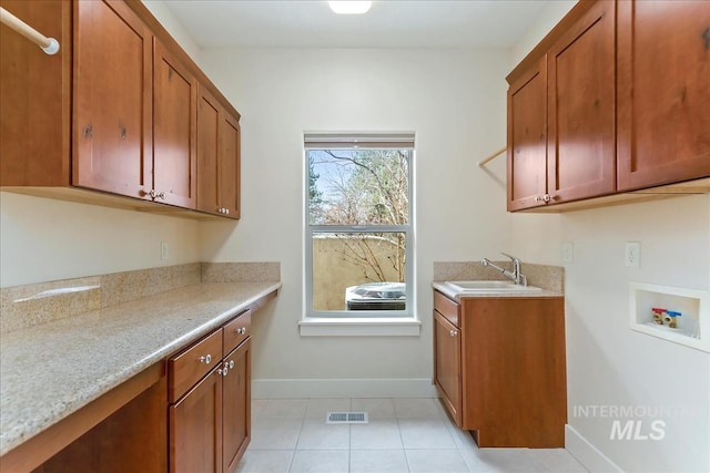 clothes washing area featuring hookup for a washing machine, baseboards, visible vents, cabinet space, and a sink