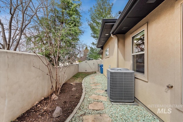 view of yard with a gate, a fenced backyard, and central AC