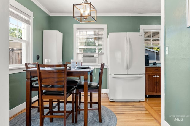 907 3rd St, Lewiston, ID 83501 - dining space featuring light wood-style flooring, ornamental molding, a chandelier, and cooling unit