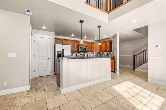 2476 S Amaya Ln, Boise, ID 83709 - kitchen with appliances with stainless steel finishes, baseboards, recessed lighting, brown cabinetry, and pendant lighting
