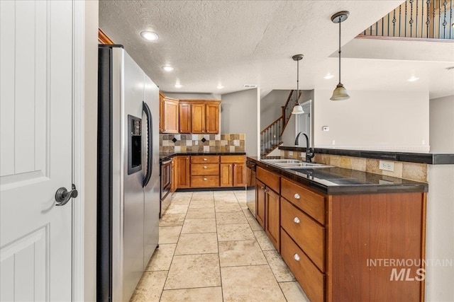 2476 S Amaya Ln, Boise, ID 83709 - kitchen featuring stainless steel appliances, a sink, brown cabinetry, decorative backsplash, and dark countertops