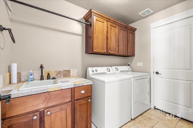 2476 S Amaya Ln, Boise, ID 83709 - washroom with cabinet space, separate washer and dryer, and a textured ceiling
