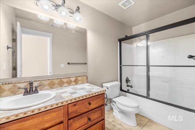 2476 S Amaya Ln, Boise, ID 83709 - full bathroom featuring vanity, toilet, tile patterned floors, shower / bath combination with glass door, and backsplash