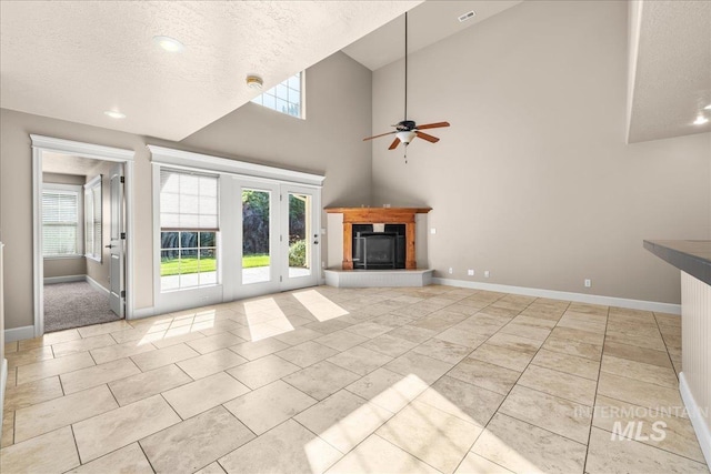 2476 S Amaya Ln, Boise, ID 83709 - unfurnished living room featuring healthy amount of natural light, ceiling fan, baseboards, a fireplace with raised hearth, and a textured ceiling
