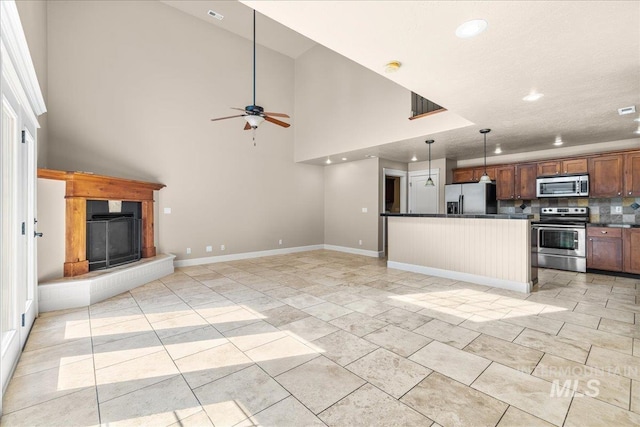 2476 S Amaya Ln, Boise, ID 83709 - kitchen with appliances with stainless steel finishes, dark countertops, open floor plan, a fireplace with raised hearth, and recessed lighting