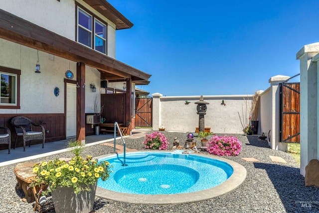 view of swimming pool featuring a patio and a hot tub