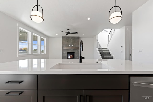 2358 E Monhegan Dr, Eagle, ID 83616 - kitchen featuring light countertops, ceiling fan, a sink, a tiled fireplace, and hanging light fixtures