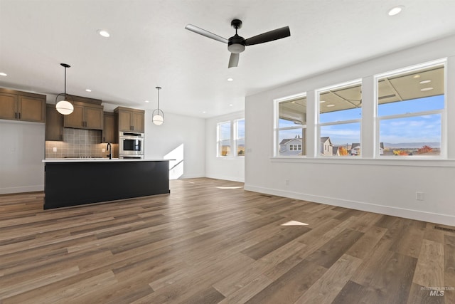 2358 E Monhegan Dr, Eagle, ID 83616 - unfurnished living room with recessed lighting, baseboards, wood finished floors, ceiling fan, and a sink