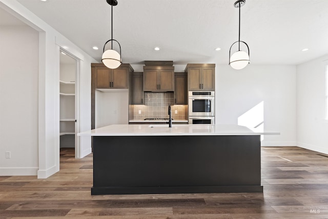 2358 E Monhegan Dr, Eagle, ID 83616 - kitchen with double oven, light countertops, baseboards, recessed lighting, and decorative backsplash