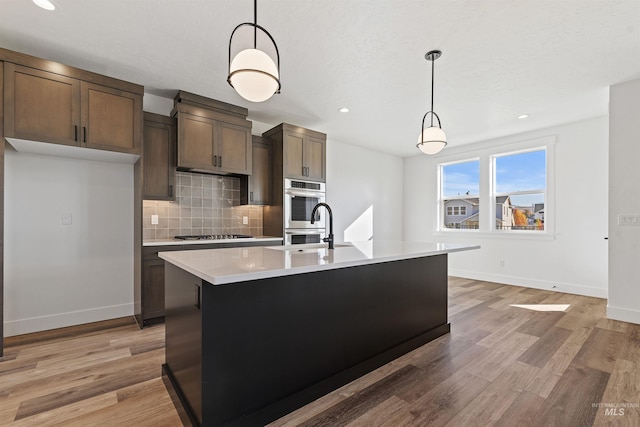 2358 E Monhegan Dr, Eagle, ID 83616 - kitchen with decorative backsplash, light countertops, baseboards, light wood-style flooring, and recessed lighting