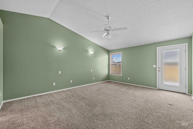 spare room with carpet floors, a textured ceiling, vaulted ceiling, and ceiling fan