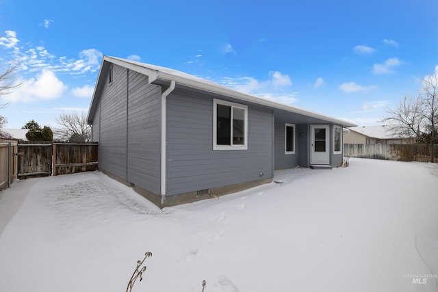 view of snow covered back of property