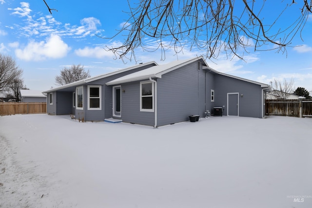 snow covered house with central air condition unit