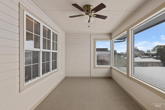 unfurnished sunroom with ceiling fan