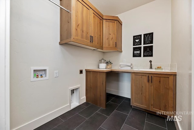 laundry room with electric dryer hookup, dark tile patterned flooring, washer hookup, cabinets, and sink