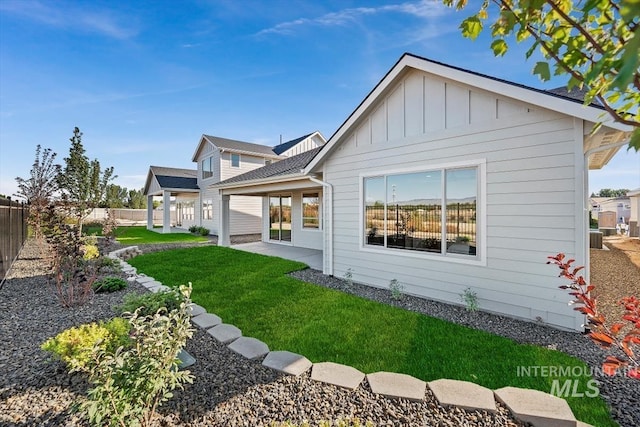 rear view of house with a yard and a patio