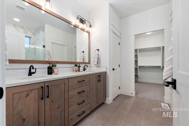 bathroom featuring tile patterned floors, vanity, and tasteful backsplash