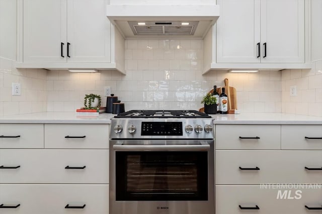 kitchen with backsplash, stainless steel gas stove, white cabinets, and extractor fan